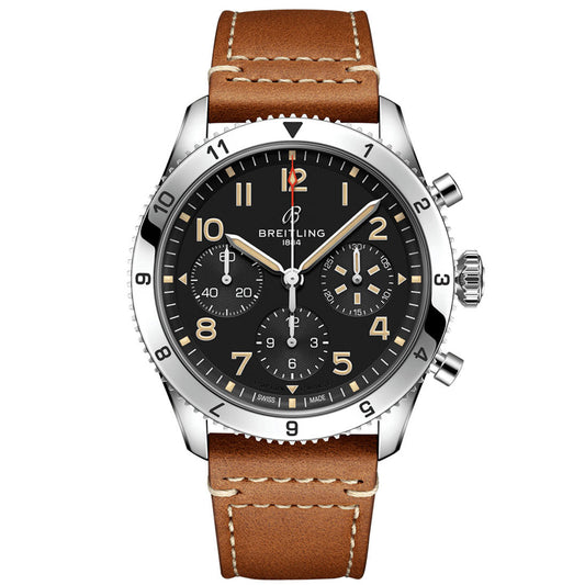 The BREITLING Classic AVI Chronograph 42 P-51 Mustang celebrates the spirit of the iconic aircraft, showcasing a black dial with three sub-dials and a date window. Its stainless steel case pairs elegantly with a brown leather strap adorned with stitching. The silver hour markers and hands are highlighted by a distinctive 12 o'clock marker, harmonizing beautifully with the watch's design.
