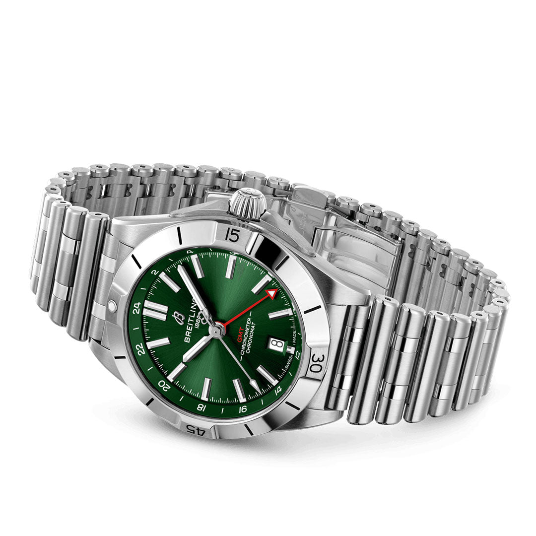The BREITLING Chronomat Automatic GMT 40, featuring a silver metal bracelet, presents a captivating green dial with a 24-hour time display powered by the precision of a Breitling Caliber 32. It includes a date window at the 3 o'clock position and a rotating bezel, elegantly meeting your dual time zone requirements.