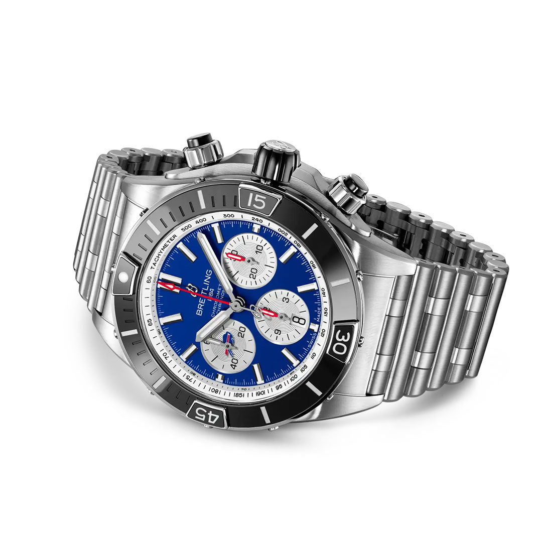 The Breitling Super Chronomat B01 NFL Buffalo Bills Edition luxury sports watch, in stainless steel with a blue dial, three subdials, silver hour markers, and a chunky linked bracelet, is displayed at an angle on a white background.
