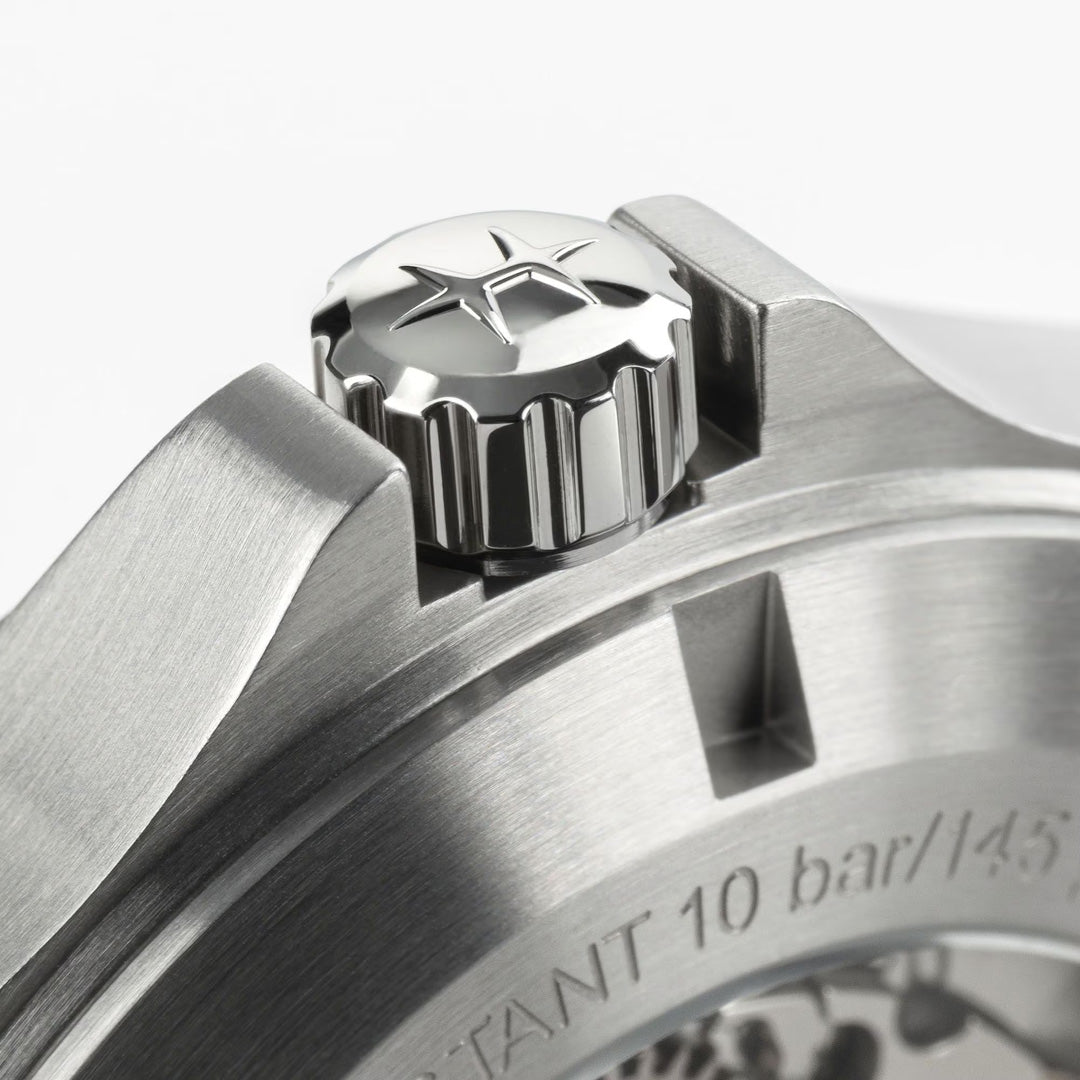 Close-up of the stainless steel crown with a star logo on the Hamilton Khaki Field King Auto 40mm Watch by Hamilton Watch, showing part of the brushed metal case and engraved military-style text.