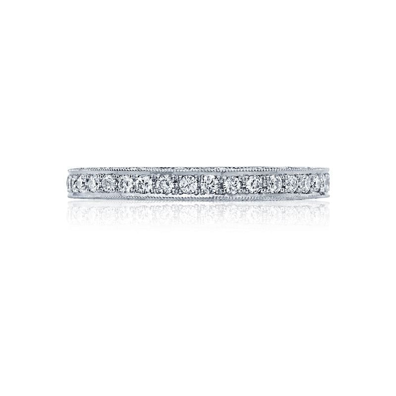 The Tacori Classic Crescent 18K White Gold Round Brilliant Pavé Diamond Anniversary Ring beautifully features a continuous line of small, round diamonds set in a narrow band. Photographed against a white background, this exquisite piece highlights the sparkling brilliance of its diamonds, making it an ideal choice for engagement rings.