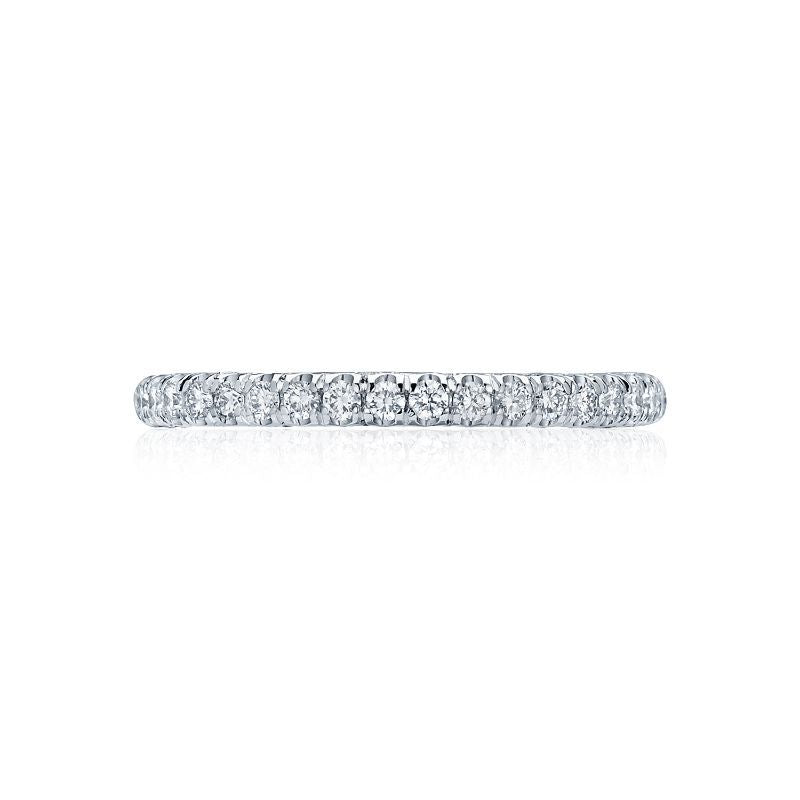 A close-up of the Tacori Petite Crescent Platinum Round Brilliant Diamond Anniversary Ring, featuring a slim design and small encrusted diamonds. Displayed against a white background, it highlights its sparkling and polished appearance—an exquisite choice for an engagement ring.