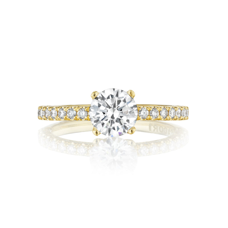 Explore the elegance of the Tacori Petite Crescent engagement ring, crafted in 18K yellow gold. Featuring a stunning round brilliant diamond solitaire at its center, this masterpiece is enhanced with smaller diamonds along the band, embodying sophistication and timeless beauty.