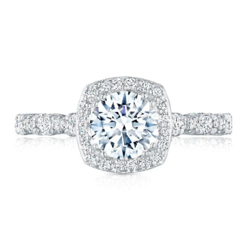 The Tacori Petite Crescent 18K White Gold Round Brilliant Halo Diamond Engagement Ring showcases a stunning round center diamond, surrounded by a halo of smaller diamonds. The band is beautifully adorned with additional diamonds, enhancing its sparkle and elegance—ideal for those seeking a dazzling engagement ring from the esteemed Tacori brand.