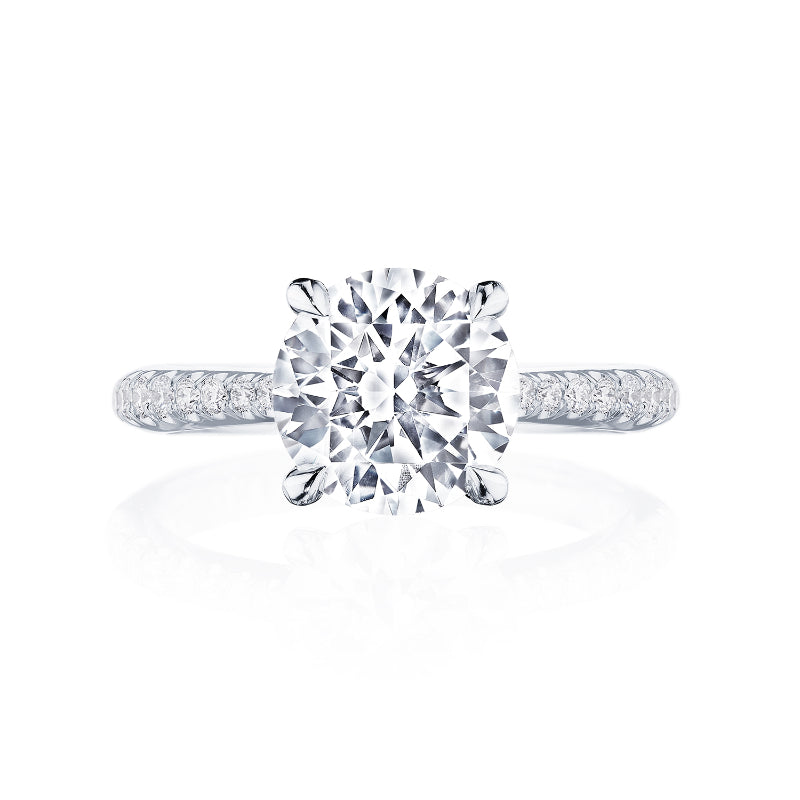 A stunning engagement ring from the Tacori Founder's Collection features a large round-brilliant diamond centerpiece, set on a lustrous platinum band adorned with smaller diamonds. The Signature Crescent design of the Tacori RoyalT Solitaire Semi Mount is elegantly showcased against a white background.