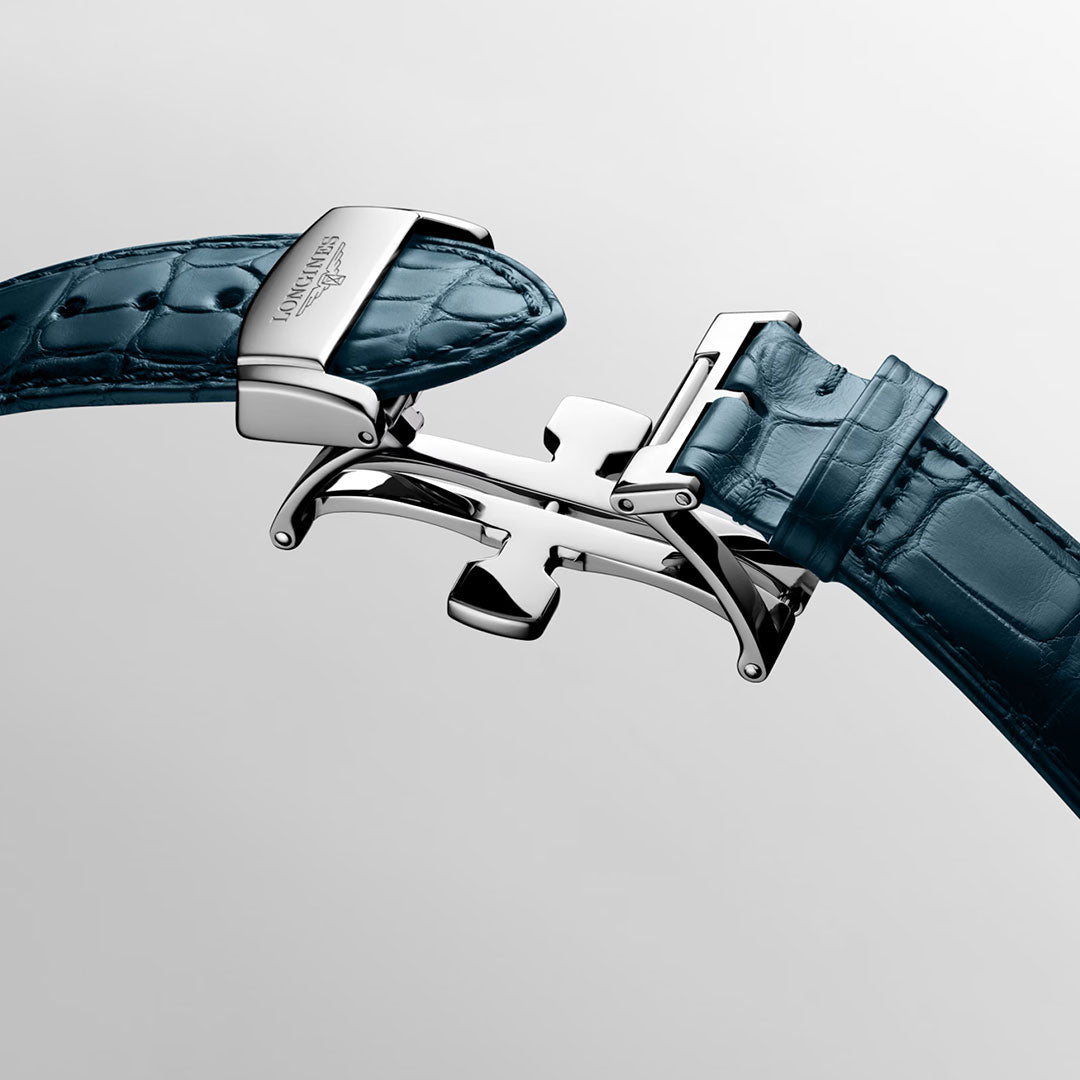 A close-up of the Longines Master Collection Automatic 41mm Watch’s blue leather strap, featuring a slightly open stainless steel deployment clasp, set against a plain light background—an exquisite detail that highlights Longines’ refined craftsmanship and the timeless elegance of this exceptional timepiece.