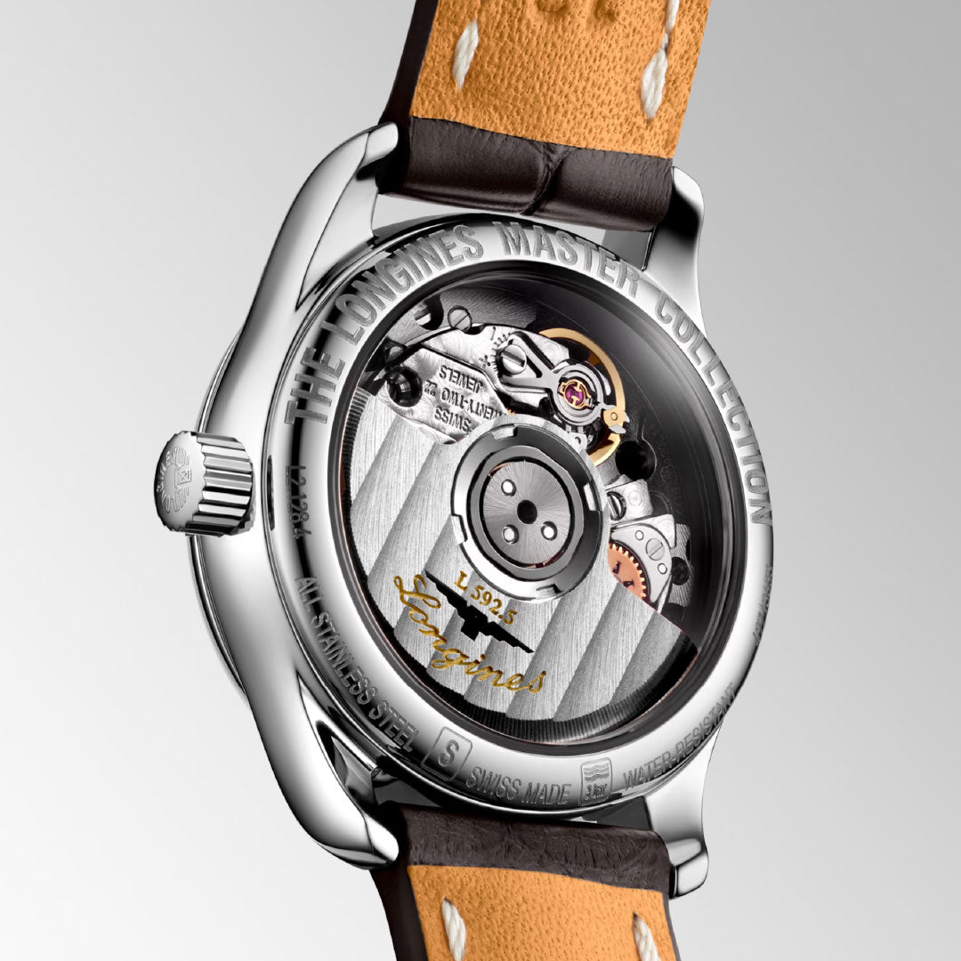Close-up of the Longines Master Collection Automatic 25.5mm Watch’s transparent case back, revealing exquisite Swiss automatic movement, engraved details, and a brown leather strap with beige stitching by Longines.