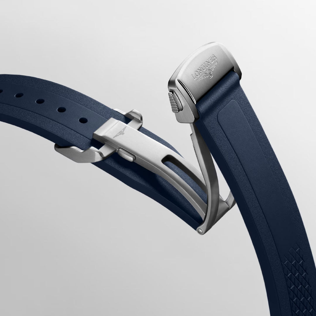 Close-up of a blue rubber strap with silver deployment clasp, engraved with the Longines logo, highlights the sporty elegance and refined design of the Longines Conquest Automatic 38mm Watch by Longines.