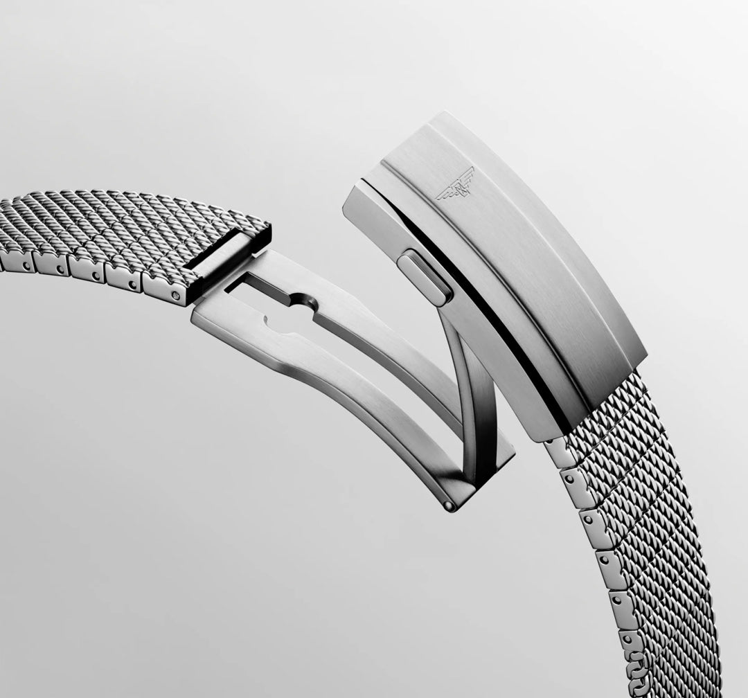 A close-up of the Longines Hydroconquest Automatic 39mm watch’s metal mesh band with a partially open clasp, showcasing detailed links and a brushed finish with the subtle Longines logo, set against a light background. Water-resistant to 300m.