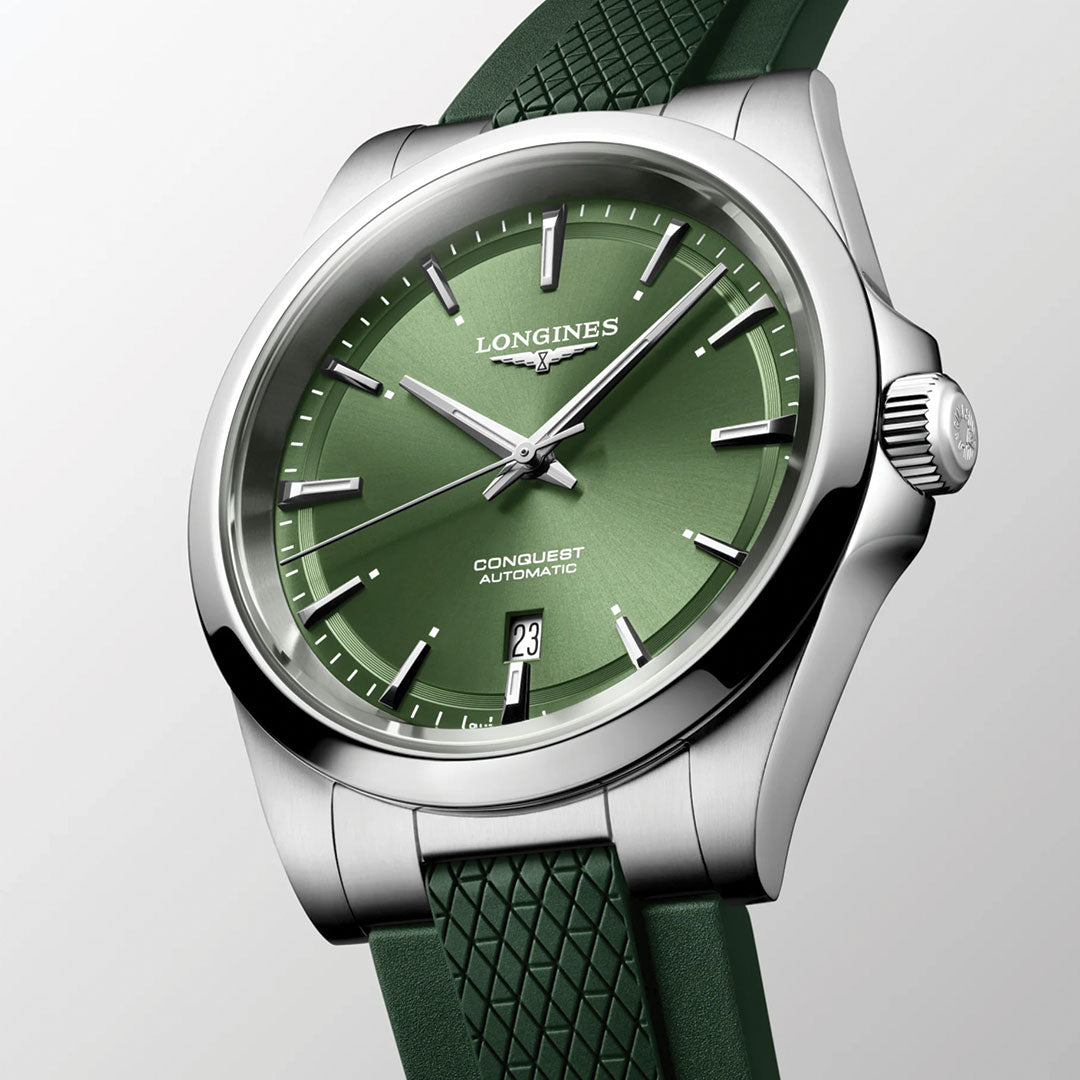 The Longines Conquest Automatic 41mm Watch, featuring a green dial, silver markers, date at 6 o’clock, and textured green strap, is displayed against a light grey background to highlight its sporty elegance.