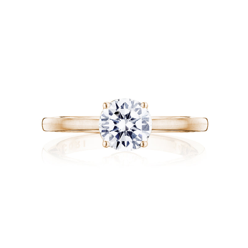 The Tacori Coastal Crescent 14K Rose Gold Round Brilliant Solitaire Semi Mount with a diamond-accented band is elegantly displayed against a white background. Skillfully crafted by TACORI gemologists, this engagement ring epitomizes elegance and sophistication, making it the ideal choice for those in search of timeless beauty.