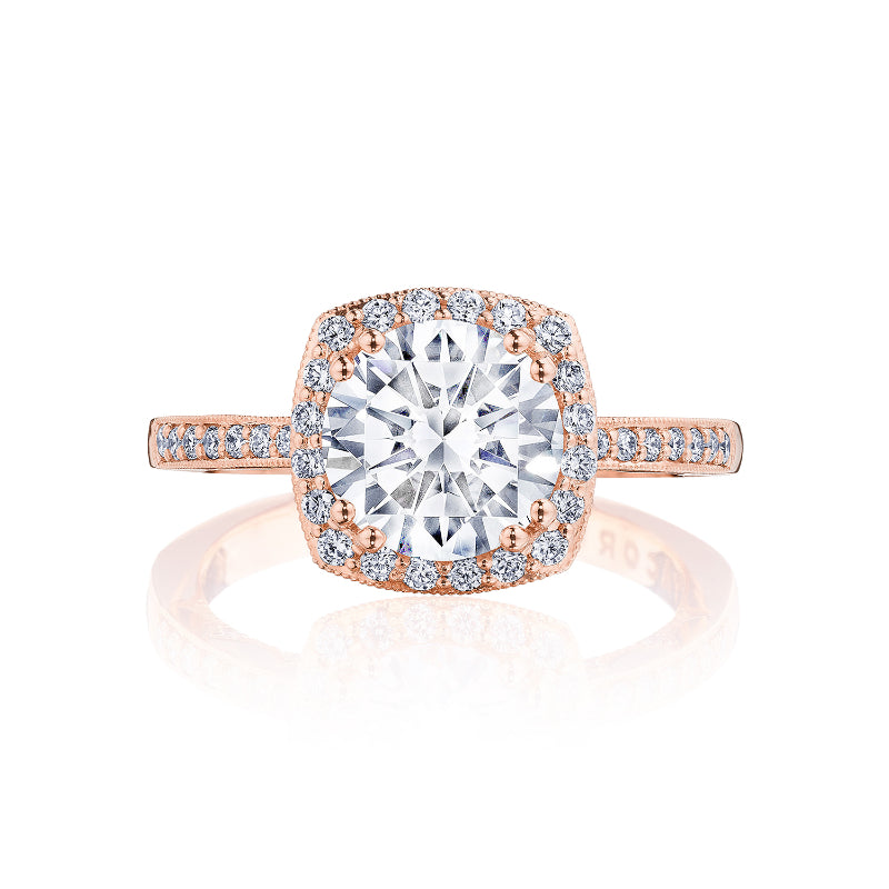 Explore the captivating allure of the Tacori Coastal Crescent engagement ring. This exquisite piece, crafted from 14K rose gold, showcases a mesmerizing round diamond at its heart, surrounded by a halo of smaller diamonds. The ring's band is elegantly accented with additional brilliant diamonds for an enchanting sparkle.
