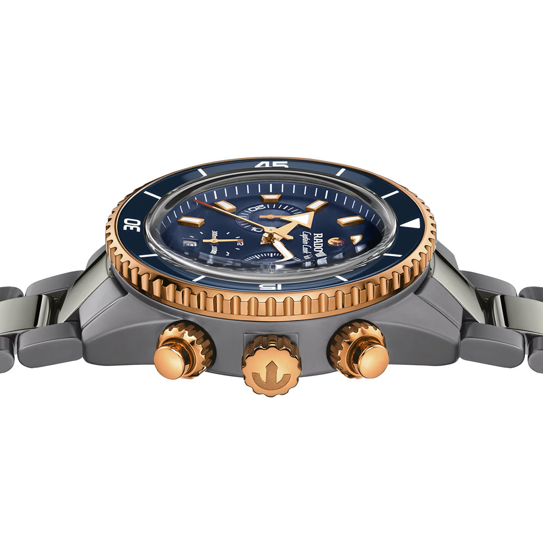 Side view of the RADO Captain Cook Hi-Tech Ceramic Chronograph Automatic 43mm Watch, showcasing its distinctive blue and gold bezel, blue dial accented with gold markers and hands, and three gold pushers on a stainless steel band—a testament to RADO’s signature style.