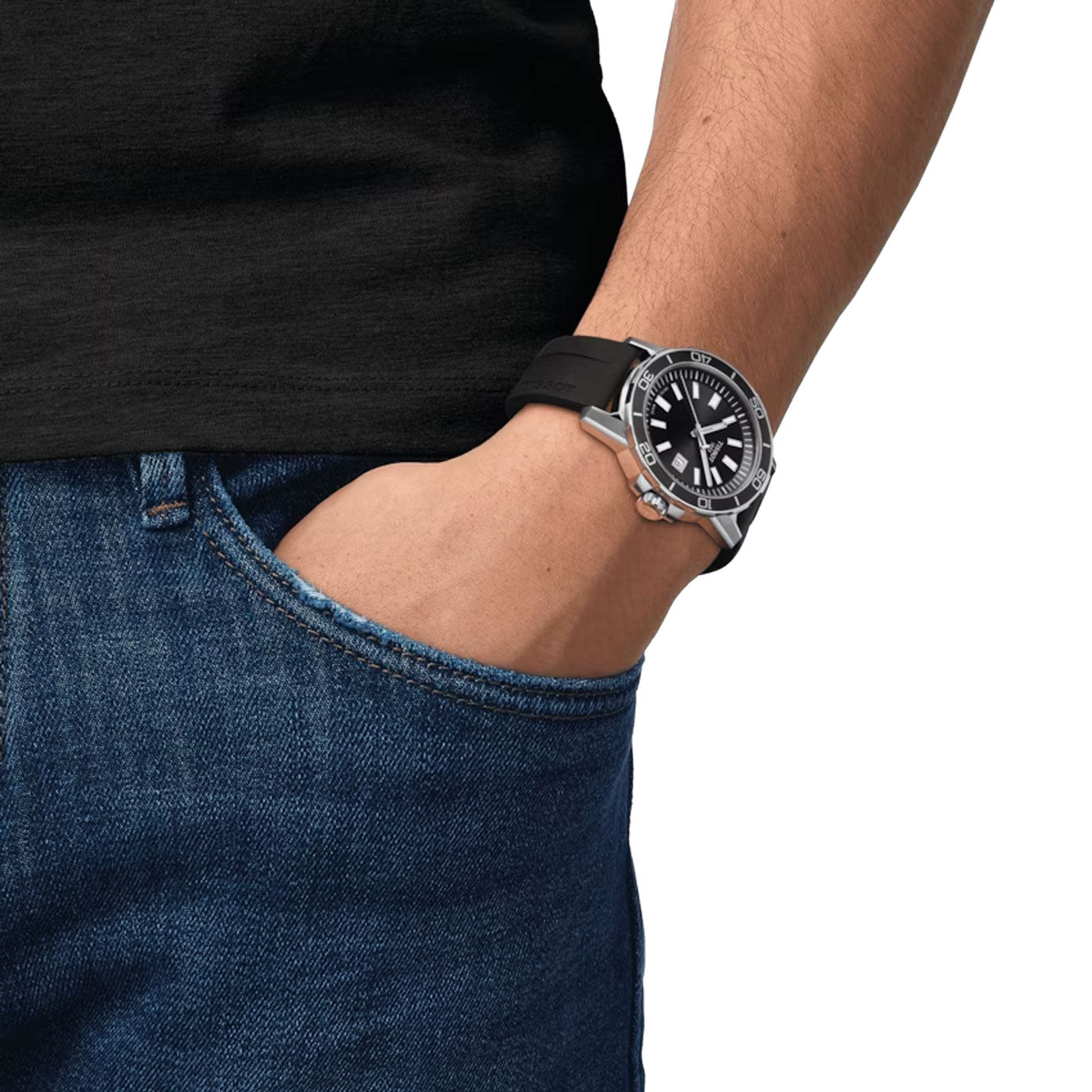 A person wearing a black t-shirt and blue jeans has their right hand in their pocket. On their left wrist is the Tissot Supersport Gent Quartz 44mm Watch, featuring a large black and silver face crafted with 316L stainless steel. The image is cropped to show only the torso and hand.
