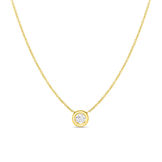 The Roberto Coin 18K Yellow Gold Bezel Set Diamond Necklace showcases a stunning round diamond secured in a smooth gold bezel setting. Its exquisite craftsmanship and minimalistic design provide an elegant and timeless appeal, making it ideal for both casual and formal wear.