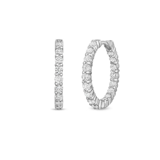 A pair of Roberto Coin 18K White Gold Diamond Hoop Earrings, elegantly crafted to showcase small sparkling diamonds. Set against a plain white background, the hoops are displayed from both side and front views, highlighting their intricate detailing—a reflection of Roberto Coin's artistry.