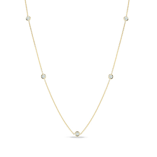 The Roberto Coin Diamonds By The Inch 18K Yellow Gold Five Station Necklace is a delicate piece featuring evenly spaced small diamond accents set in circular bezels. This simple, elegant design by Roberto Coin highlights the sparkle of five diamonds and forms a slight curve, indicating a natural drape.