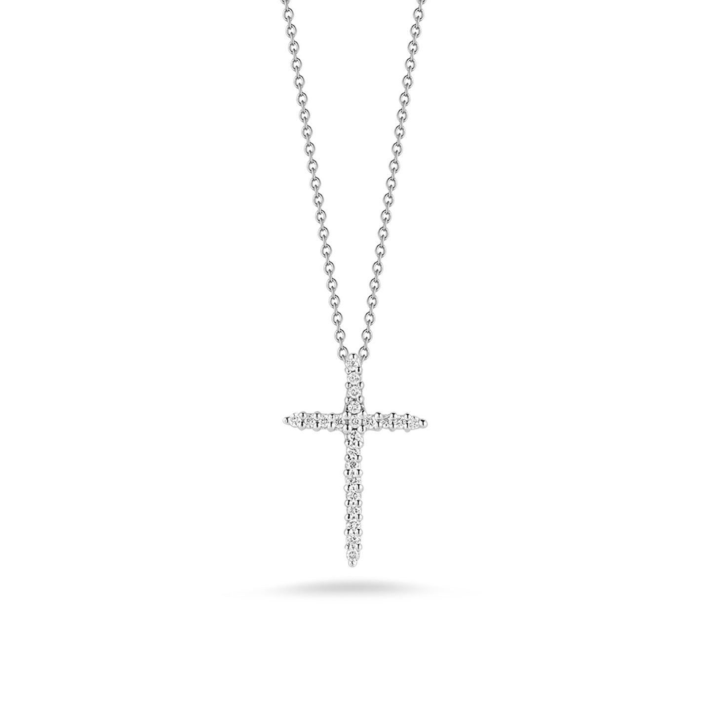 The Roberto Coin Tiny Treasures 18K White Gold Diamond Cross Necklace Pendant showcases embedded diamonds and features a silver chain. The elegant cross, crafted from 18K white gold, hangs centrally against a white background, casting a delicate shadow beneath it.