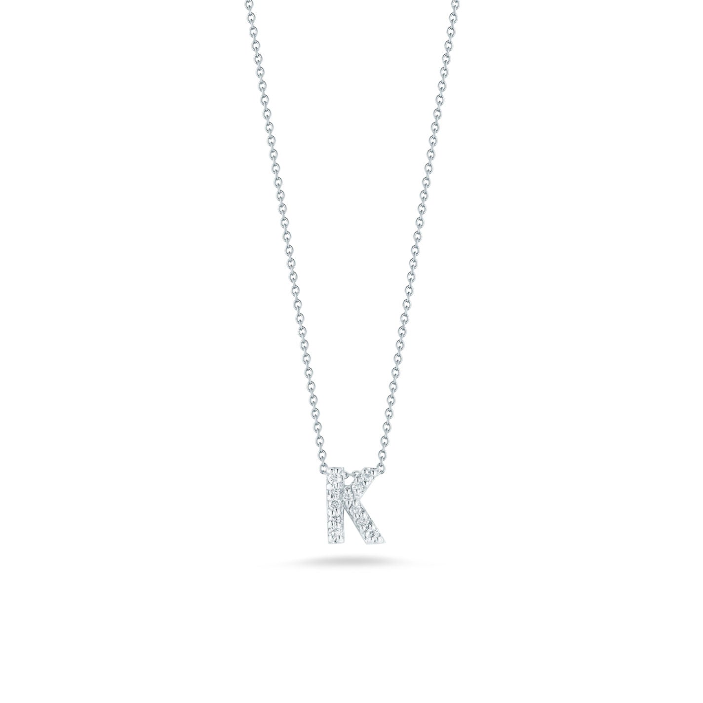 The Roberto Coin Tiny Treasures Love Letter 18K White Gold Diamond Initial Necklace Pendant features a graceful "K" pendant adorned with small dazzling diamonds, crafted from exquisite 18K white gold, set against a plain white background.