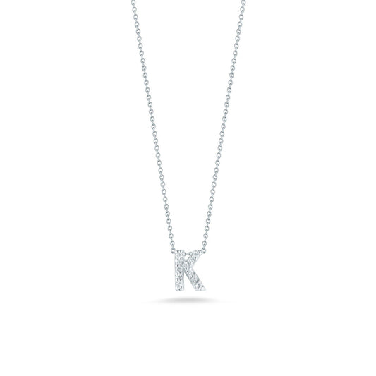 The Roberto Coin Tiny Treasures Love Letter 18K White Gold Diamond Initial Necklace Pendant features a graceful "K" pendant adorned with small dazzling diamonds, crafted from exquisite 18K white gold, set against a plain white background.