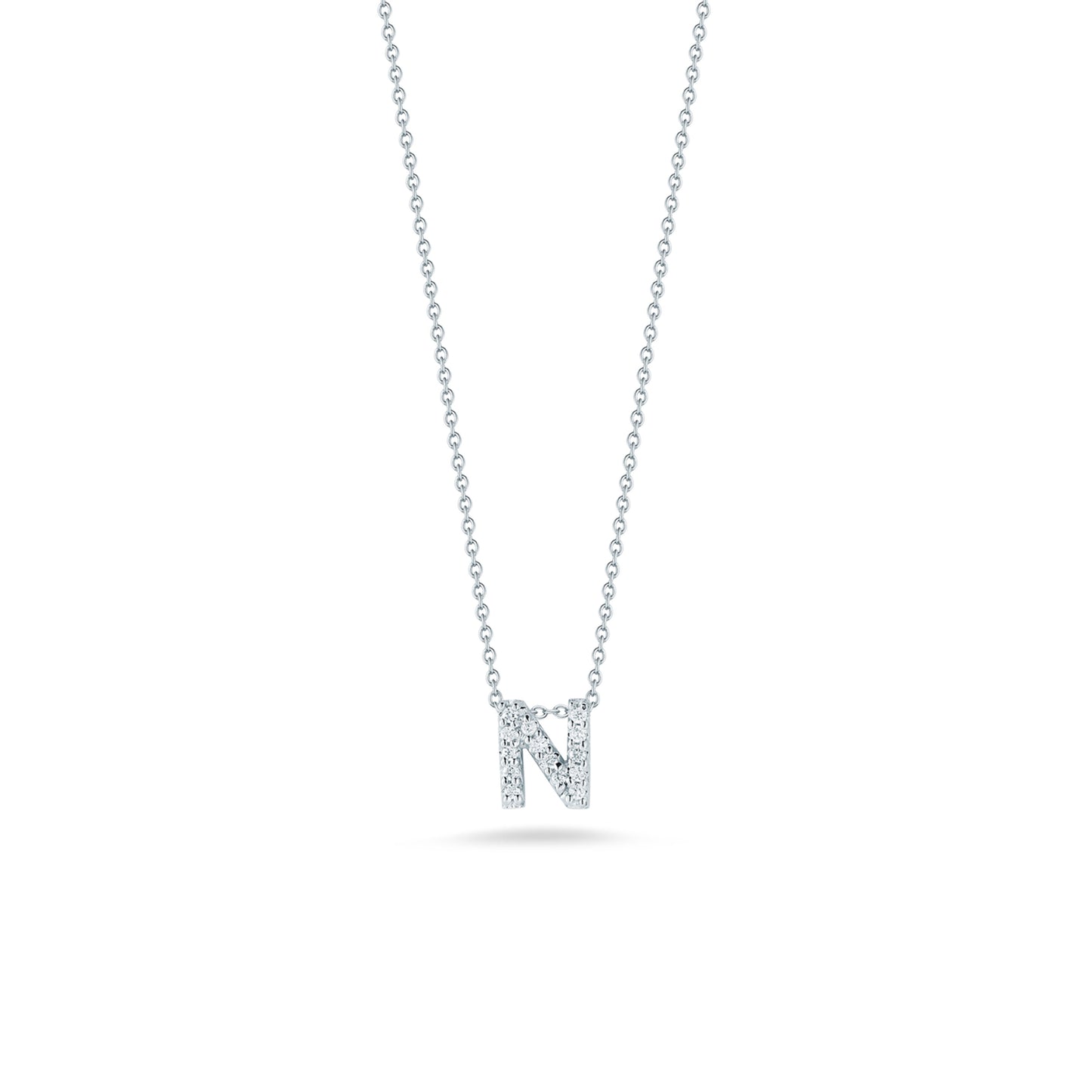 This exquisite necklace from the Roberto Coin Tiny Treasures Love Letter Collection showcases a pendant shaped like the letter "N," embellished with shimmering diamonds. Expertly crafted in 18K white gold, it gracefully stands out against a pristine white backdrop.