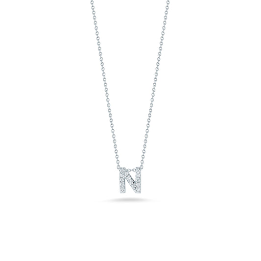 This exquisite necklace from the Roberto Coin Tiny Treasures Love Letter Collection showcases a pendant shaped like the letter "N," embellished with shimmering diamonds. Expertly crafted in 18K white gold, it gracefully stands out against a pristine white backdrop.