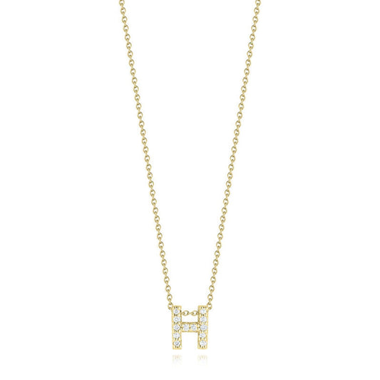 The Roberto Coin Tiny Treasures Love Letter necklace features an 18K yellow gold pendant adorned with a small, diamond-studded letter "H," elegantly suspended on a gold chain against a white background.