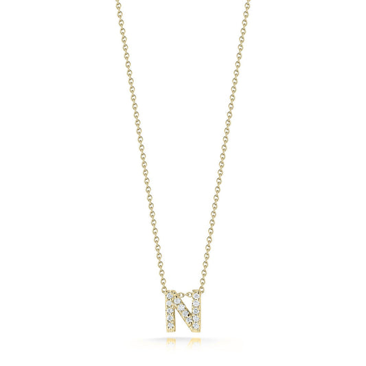 The Roberto Coin Tiny Treasures Love Letter 18K Yellow Gold Diamond Initial Necklace Pendant features a gold necklace with an "N"-shaped pendant, embellished with approximately 0.07 tcw of dazzling diamonds, suspended from an 18″ delicate chain. The plain white background gracefully showcases the jewelry by Roberto Coin.