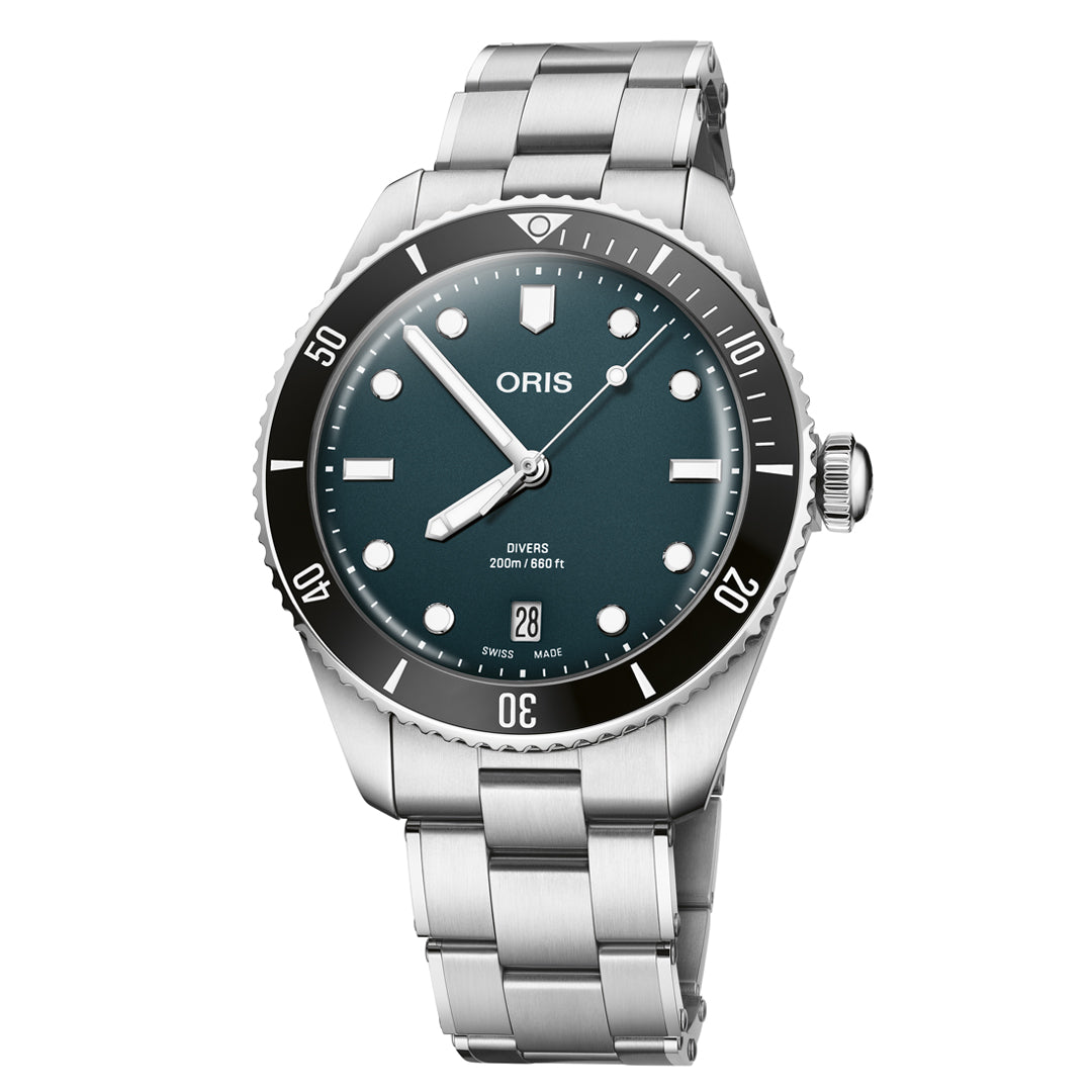 The ORIS Divers Date Calibre 733-1 Automatic Winding 39mm watch features a teal dial, round markers, date at 6, black ceramic bezel, and stainless steel bracelet. The Swiss-made timepiece is shown angled on a white background.