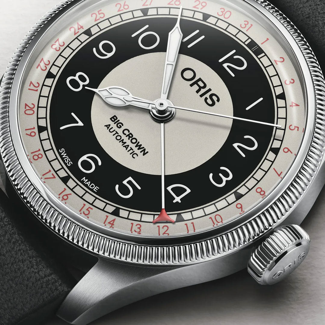 Close-up of an ORIS Big Crown Pointer Date Bullseye Automatic 38mm watch featuring a grey and black dial, silver case, Arabic numerals, red 24-hour markers, fluted bezel, and a black leather strap.