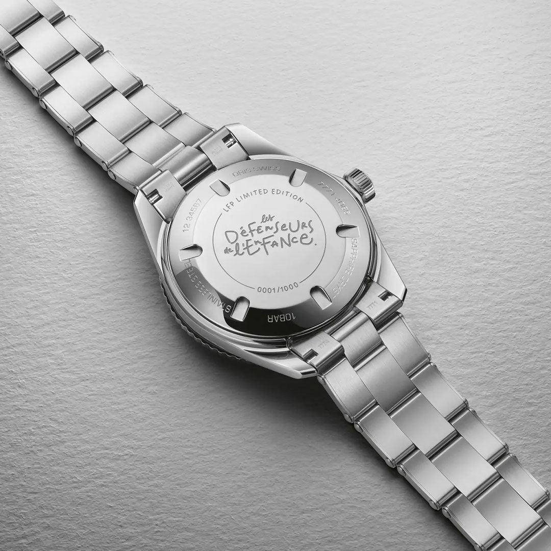 An ORIS Divers LFP Limited Edition Automatic Winding 38mm watch rests face down, revealing its engraved back: "Défenseurs de l’France," signifying it as a Ligue de Football Professionnel limited edition, number 1000/1000.