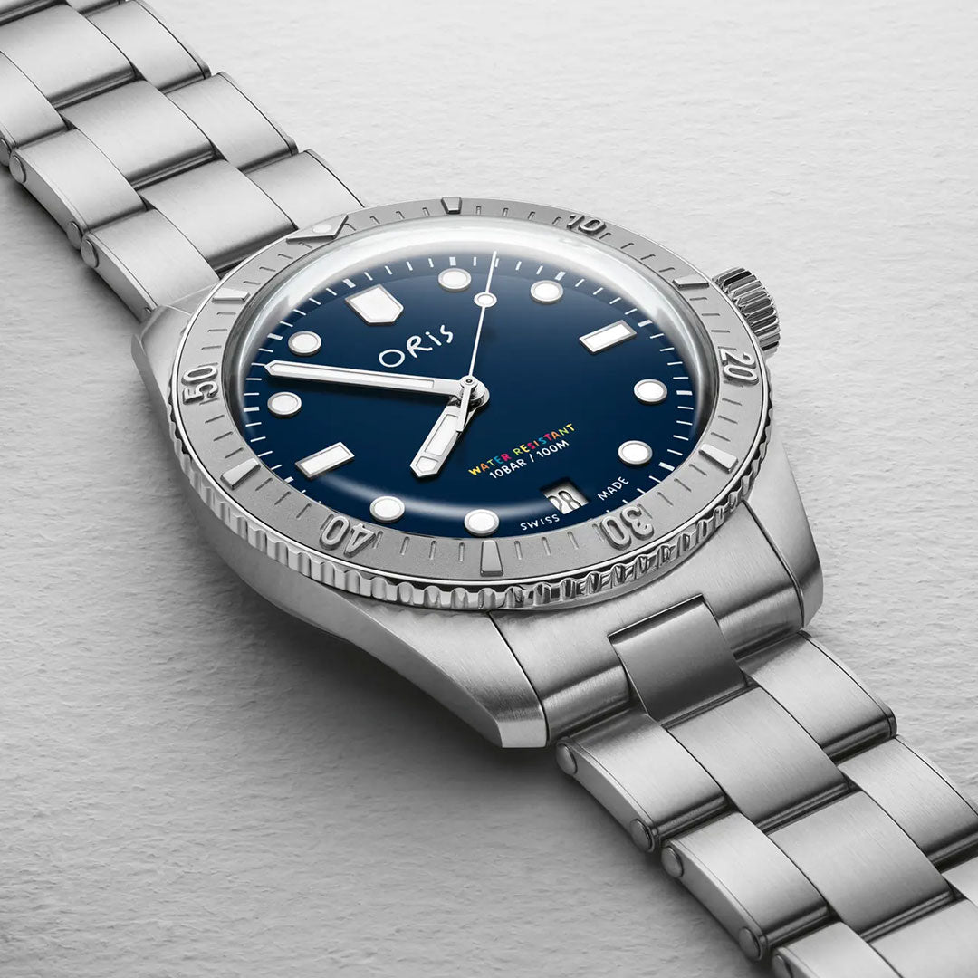 The ORIS Divers LFP Limited Edition Automatic Winding 38mm watch features a stainless steel case, metallic band, blue dial with white hour markers, and silver bezel, displayed on a light gray textured surface.