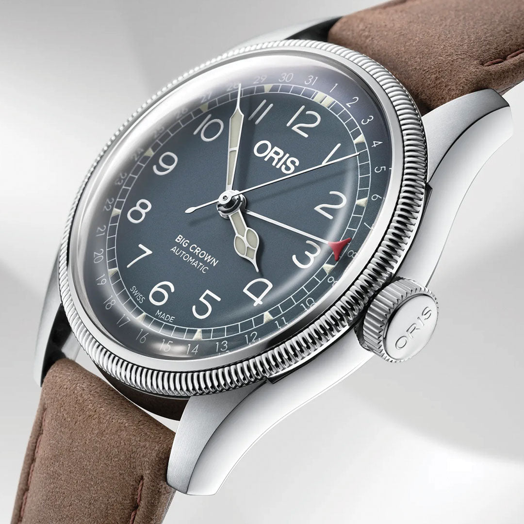 A close-up of the ORIS Big Crown Pointer Date Calibre 754 Automatic 40mm watch, featuring a grey dial with white numerals, silver hands, and a brown leather strap. The textured bezel and signature crown enhance its classic pilot style.