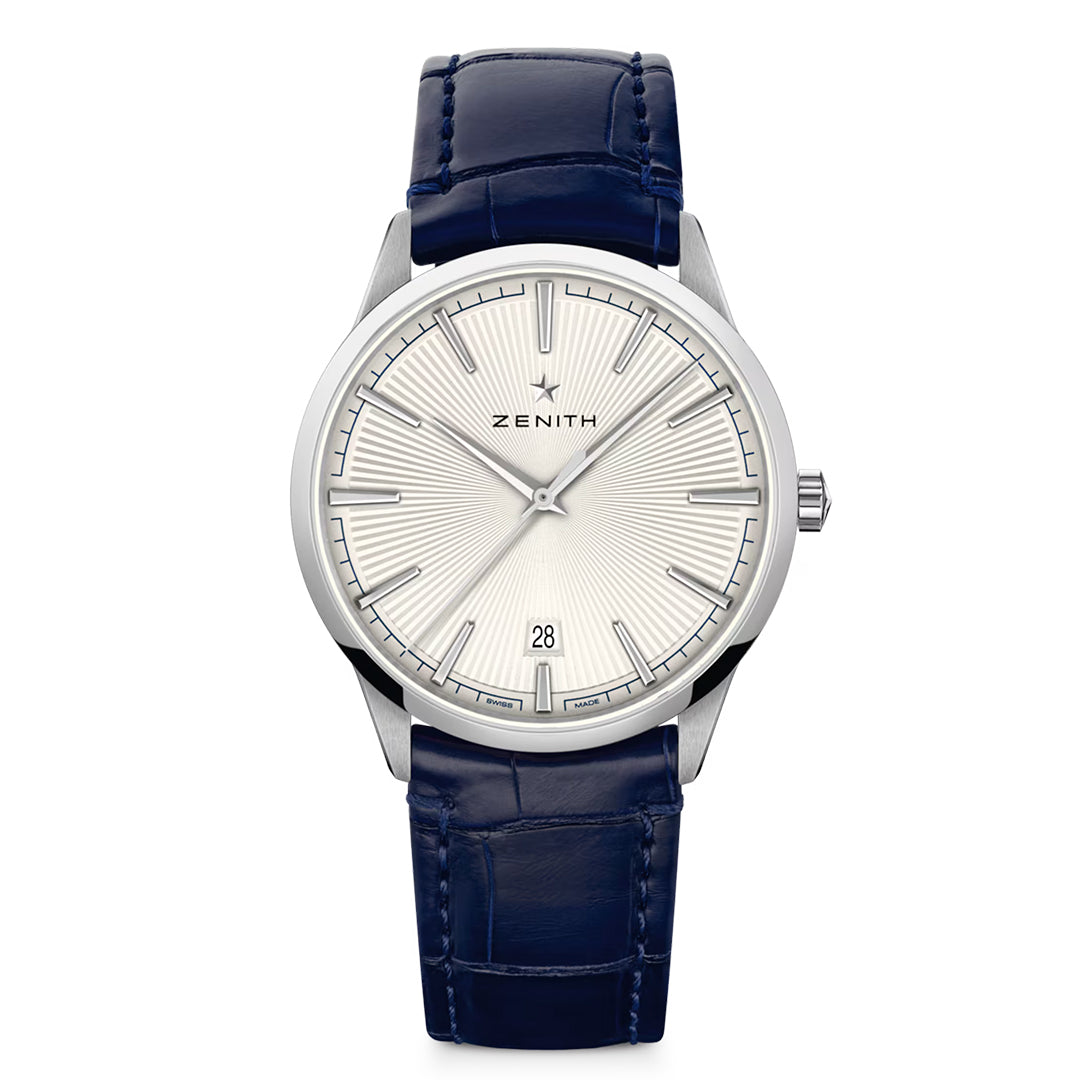 The ZENITH Elite Classic Elite 670 40.5mm Watch is a silver wristwatch featuring a white dial with simple hour markers, an automatic winding mechanism, a small date window, dark blue leather strap, and sleek stainless steel case. The brand "Zenith" is proudly displayed on its face.