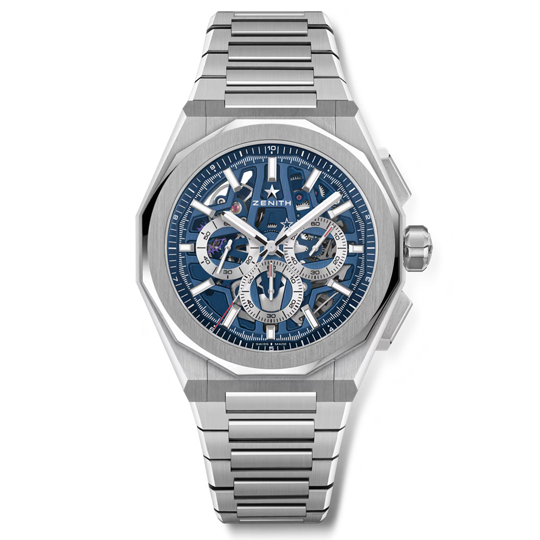 The ZENITH Defy Skyline Chronograph Skeleton El Primero 3600SK features a silver metallic bracelet and a bold 42mm steel octagonal case, housing a blue skeletonized dial with intricate details. The Zenith logo is near the top, accompanied by silver hour markers.