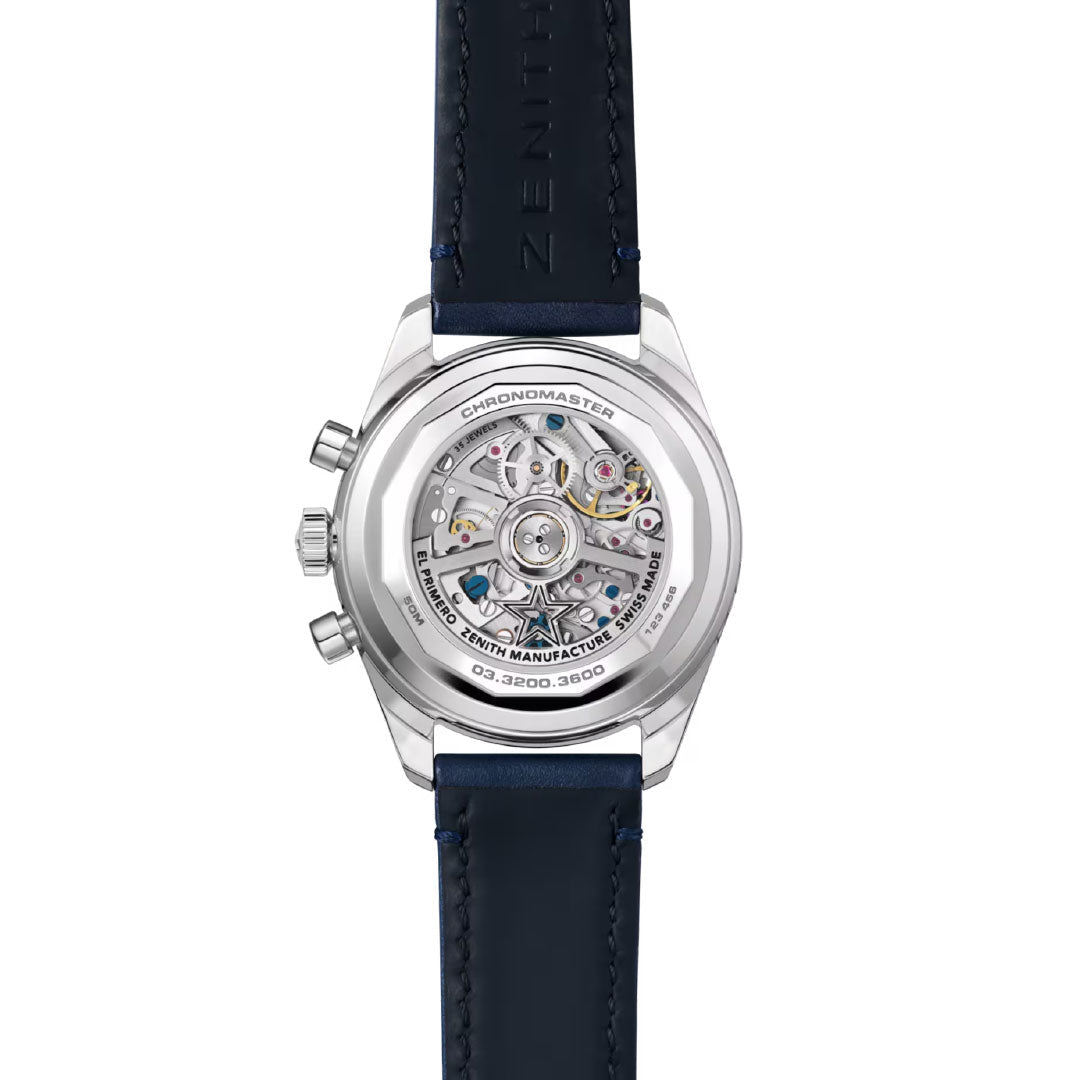 A close-up of the Zenith Chronomaster Original El Primero 3610 38mm watch showcases its intricate automatic chronograph movement through a transparent case back and features a blue leather strap with visible stitching.