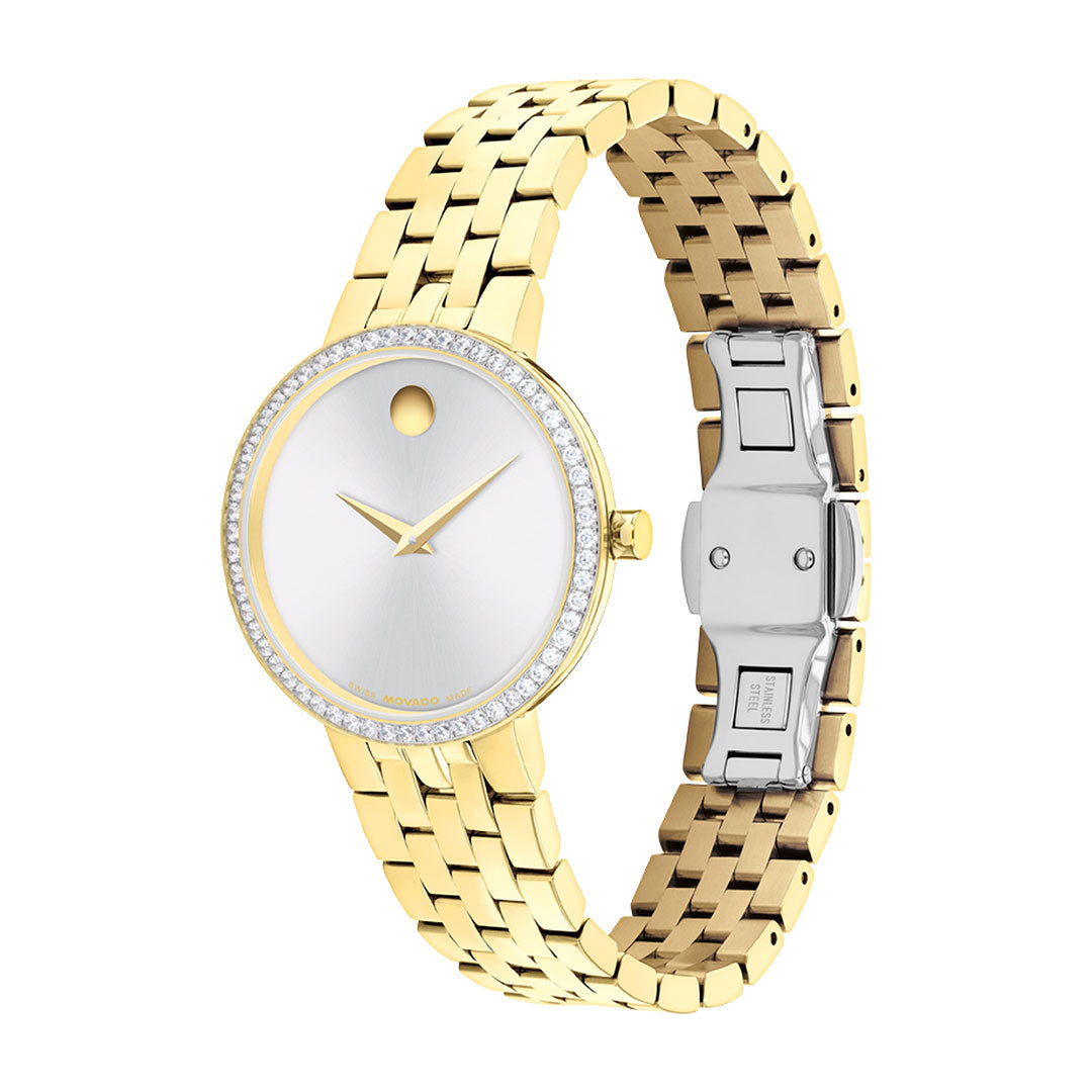 The Movado Museum Classic Quartz 29.5mm Watch by Movado features a gold link bracelet with a stainless steel clasp, a round silver face with a minimalist, numberless design inspired by the iconic Museum Classic style, and is accented with a lab-grown diamond pavé bezel.
