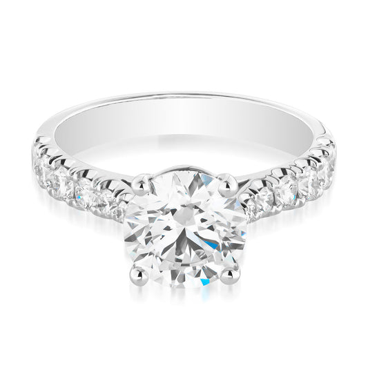 The Raffi&Co.® 18K White Gold engagement ring showcases a magnificent round brilliant lab-grown diamond at its center, complemented by mined accent diamonds elegantly arranged along the band.