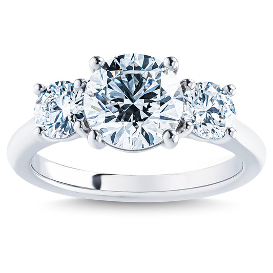 Experience the elegance of the Raffi&Co.® Signature 14K White Gold Round Brilliant Three Stone Diamond Engagement Ring, showcasing a dazzling central round diamond accompanied by two smaller round diamonds, all beautifully set on a polished 14K white gold band.