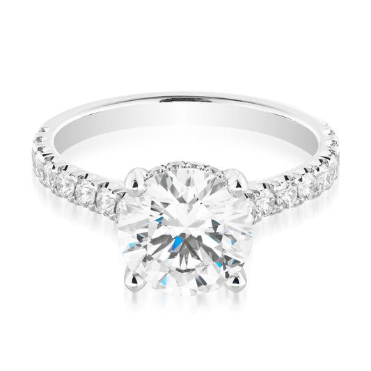 Introducing the Raffi&Co.® 14K White Gold Round Brilliant Hidden Halo Diamond Engagement Ring—a breathtaking piece that features a prominent GIA-certified round diamond at its center. Enhanced with a discreet hidden halo and set with smaller diamonds along the band, this ring exemplifies timeless elegance.