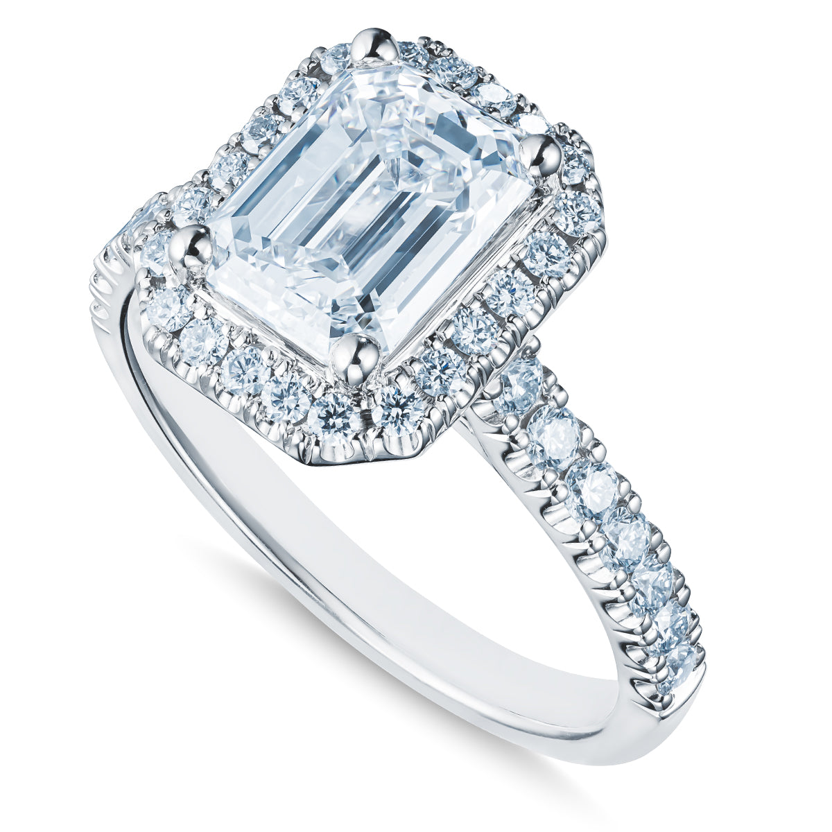 The Raffi&Co.® 18K White Gold Emerald Halo Diamond Engagement Ring features a breathtaking emerald-cut diamond at its center, surrounded by an array of smaller sparkling stones that form an exquisite halo. The band is adorned with round diamonds, enhancing its elegance and brilliance.