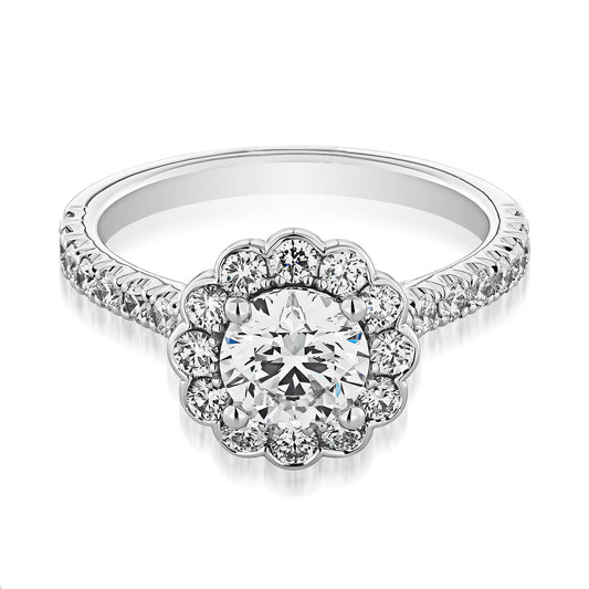 Introducing the Raffi&Co.® 14K White Gold Round Brilliant Halo Diamond Engagement Ring, a stunning piece from Raffi&Co. This beautiful ring showcases a large central diamond surrounded by a halo of smaller diamonds, while the band is elegantly embellished with additional sparkling diamonds for a truly dazzling design.