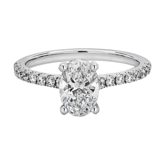 The Raffi&Co® 14K White Gold Oval with Round Brilliant Hidden Halo Diamond Engagement Ring showcases an oval-shaped diamond as the centerpiece, surrounded by smaller round diamonds along the band, providing a breathtaking display of elegance and brilliance.