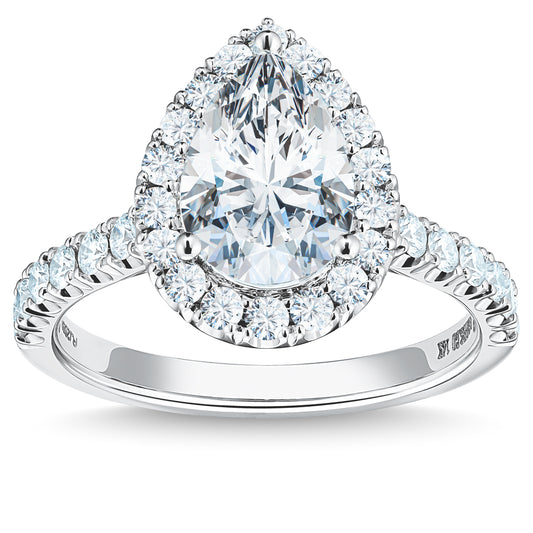 The Raffi&Co.® 14K White Gold Pear Halo Diamond Engagement Ring features a breathtaking pear-shaped diamond encircled by a halo of smaller round diamonds. The elegant silver band is embellished with additional small diamonds extending halfway down, resulting in an exquisite and sophisticated design suitable for any occasion. GIA certified.