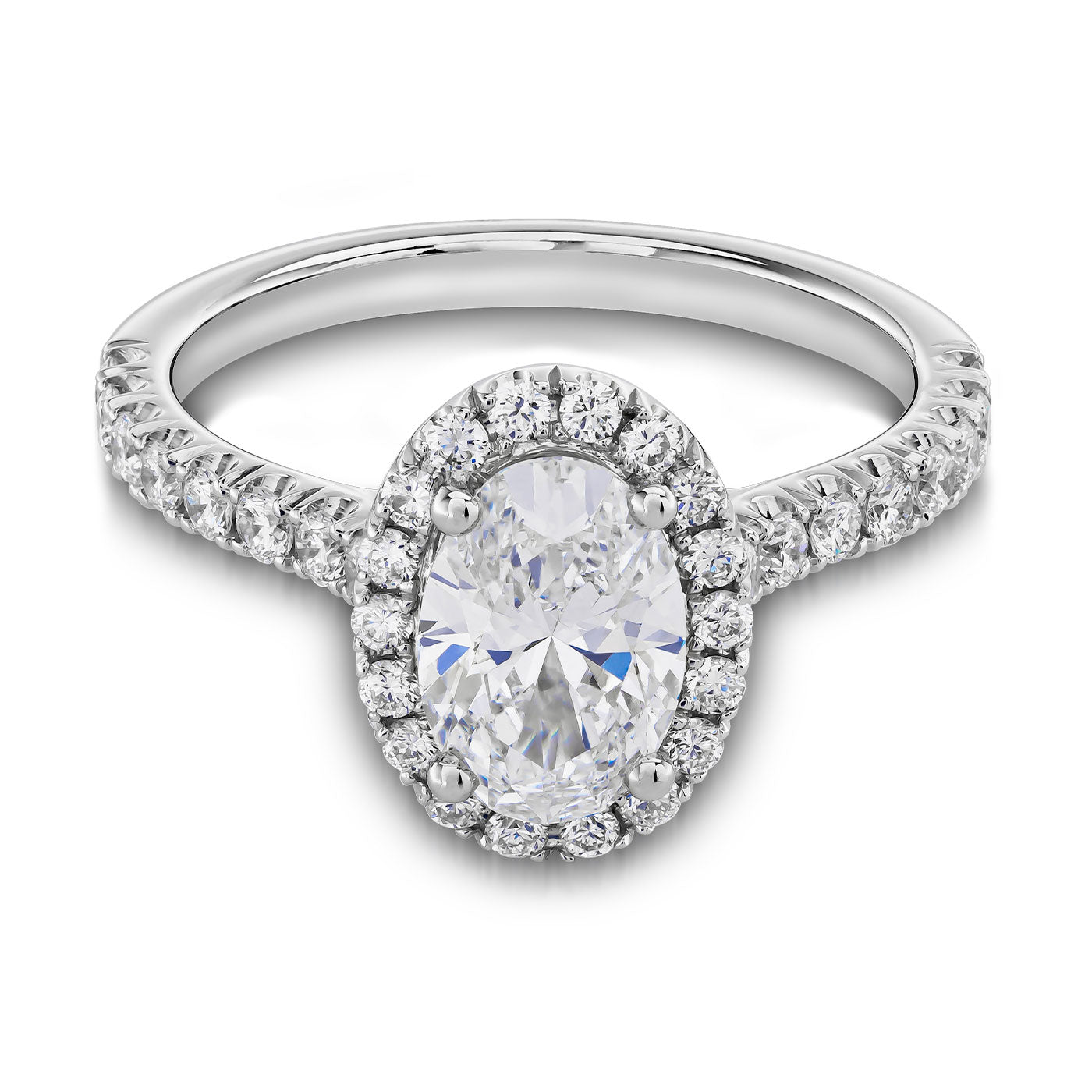 Introducing the Raffi&Co.® 14K White Gold Oval with Round Brilliant Halo Diamond Engagement Ring—an exquisite piece featuring a prominent GIA Certified oval diamond encircled by a stunning halo of smaller diamonds. This elegant design is complemented by a band adorned with additional small diamonds, enhancing its sparkle and brilliance.