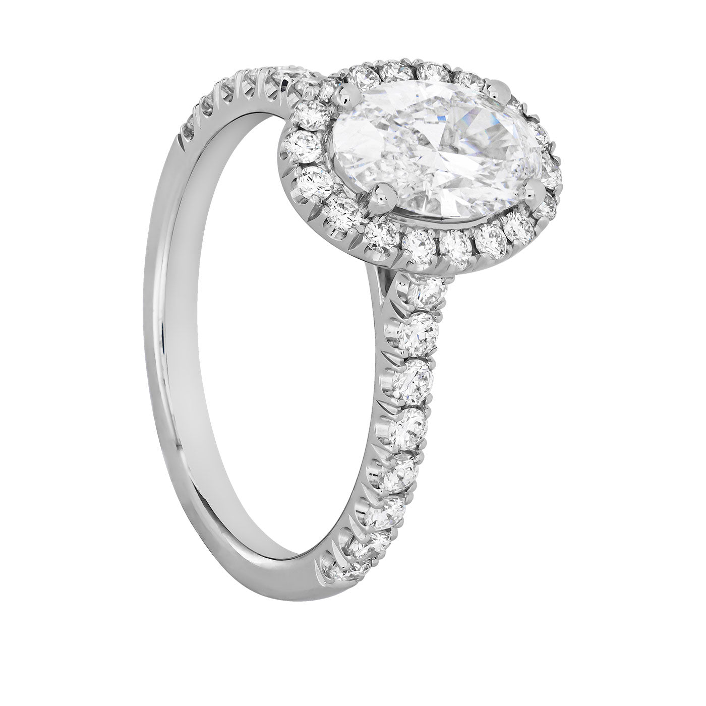 The Raffi&Co.® 14K White Gold Oval with Round Brilliant Halo Diamond Engagement Ring captivates with its oval-cut diamond encircled by a halo of smaller diamonds. The band, adorned with additional diamonds, amplifies the shine and sophistication, making it an ideal choice for those in search of timeless elegance.