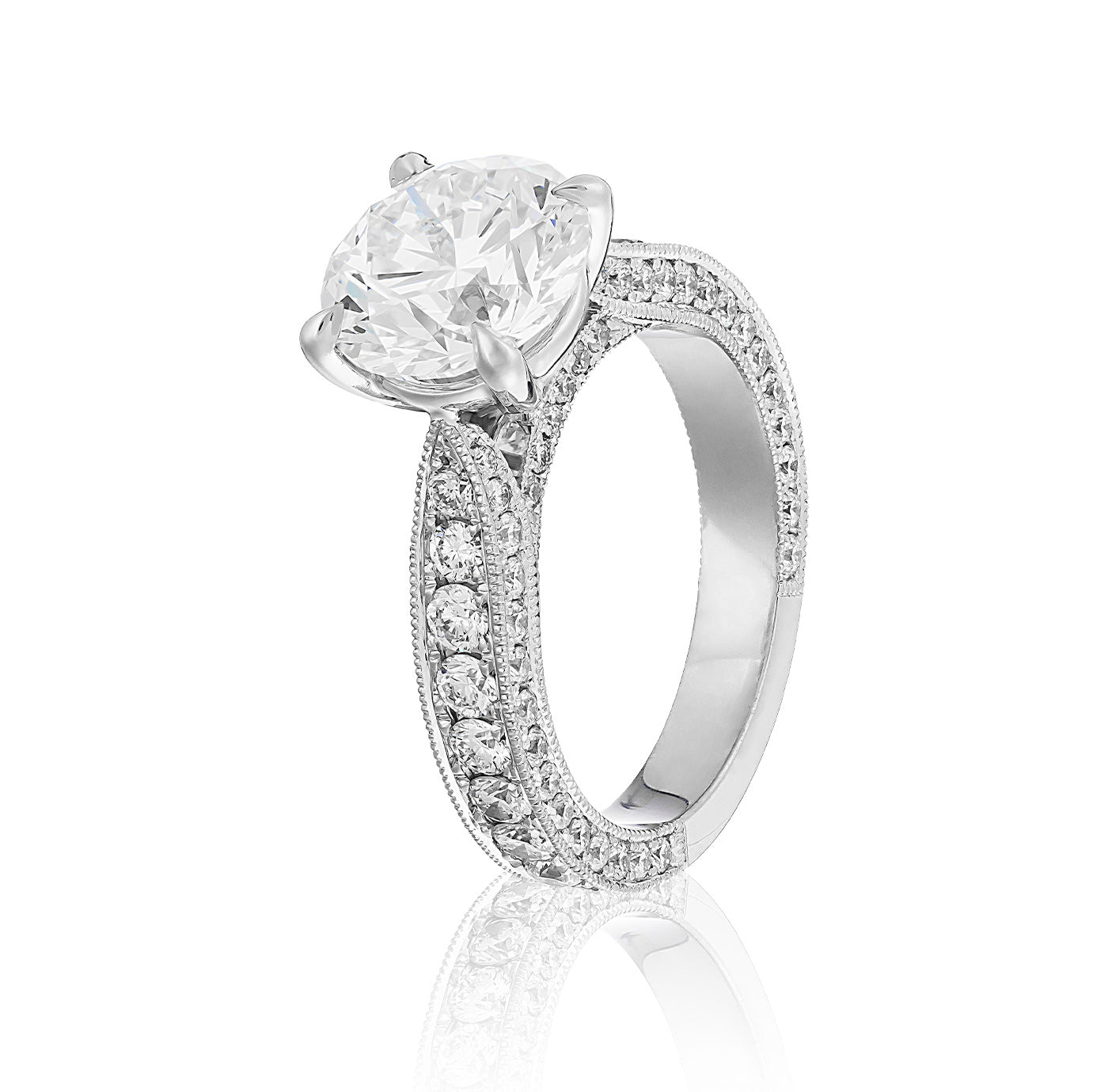 The Raffi&Co.® 18K White Gold Round Brilliant Solitaire Diamond Engagement Ring features a stunning solitaire diamond centerpiece. The band, elegantly adorned with smaller diamonds along the sides, enhances its elegance and sparkle, making it a timeless piece for a memorable proposal.