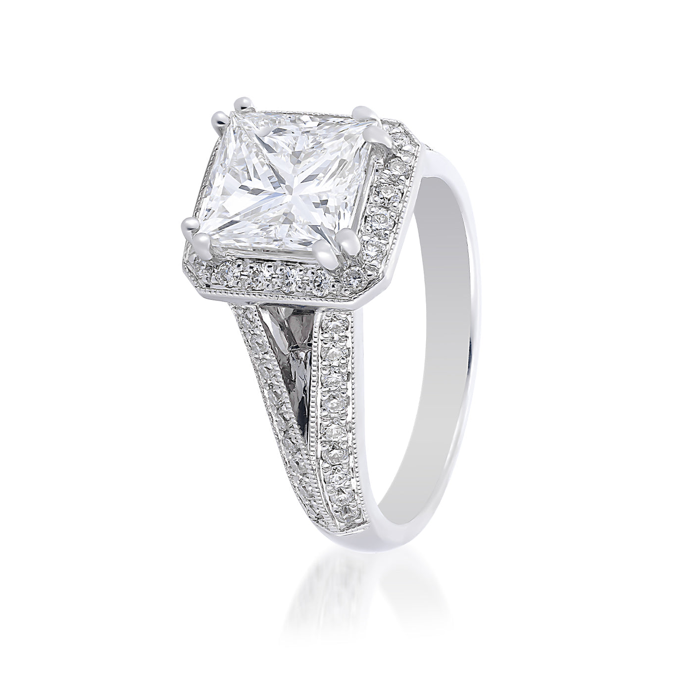 The Raffi&Co. 14K White Gold Princess Cut Halo Diamond Engagement Ring features a striking large princess-cut diamond at its center, elegantly encircled by smaller diamonds. The band is embellished with a row of sparkling diamonds, highlighting its sophisticated and luxurious design against a plain white background.