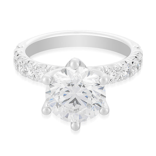 The Raffi&Co.® 14K White Gold Round Brilliant Solitaire Lab Diamond Engagement Ring features a prominent round lab diamond in a six-prong setting, enhanced by smaller diamonds along the band for added sparkle and elegance, showcasing a classic and sophisticated design that highlights the central gemstone.