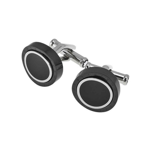The Montblanc Meisterstuck Contemporary Turning Black PVD Cufflinks are elegantly showcased against a white backdrop. These cufflinks, crafted from stainless steel by Montblanc, boast a contemporary round design with black and silver details and possess a shiny, polished finish akin to onyx.
